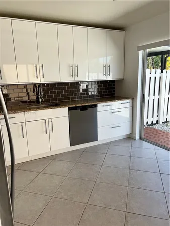 a kitchen with a white cabinets and sink