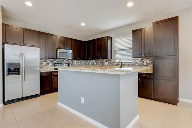 a kitchen with granite countertop a stove top oven and cabinets