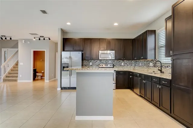 a kitchen with stainless steel appliances granite countertop a sink and a stove