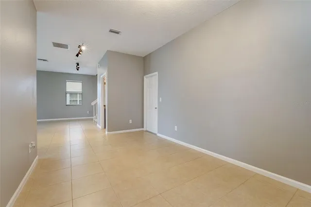 a view of an empty room with a ceiling fan and window