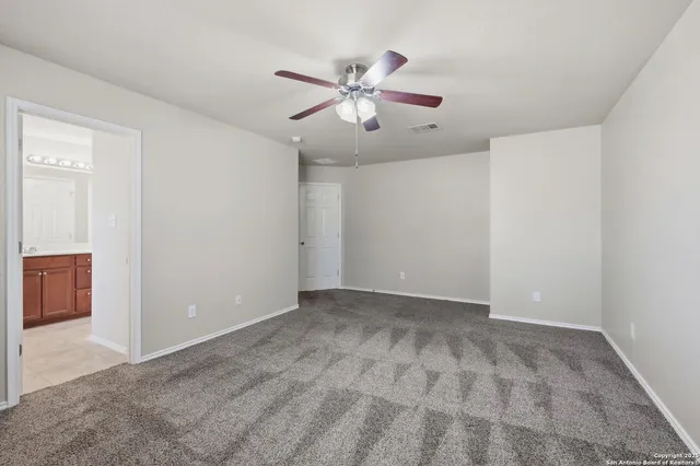 a view of an empty room with a ceiling fan