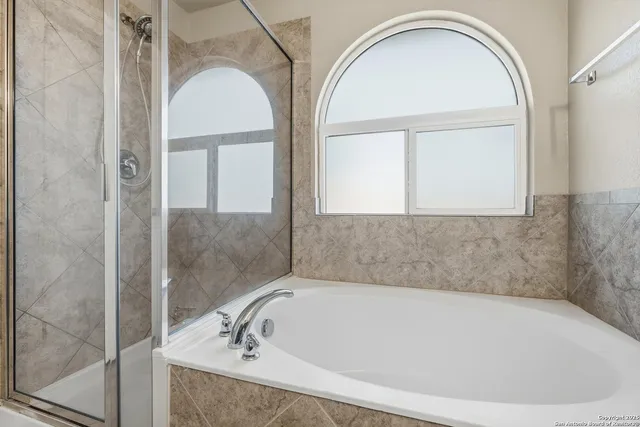a bathroom with a tub and mirror