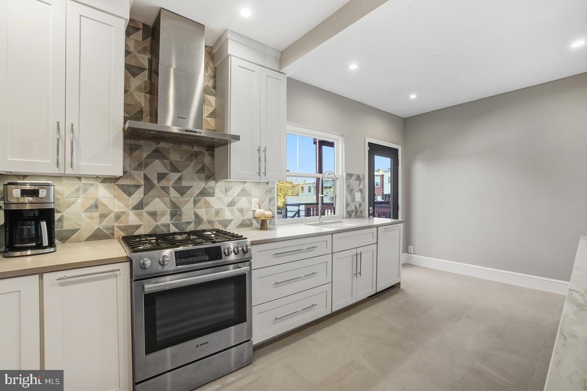 417 Emerson Street Northwest Washington, DC 20011 - Photo 21 of 47 a kitchen with stainless steel appliances granite countertop white cabinets and window