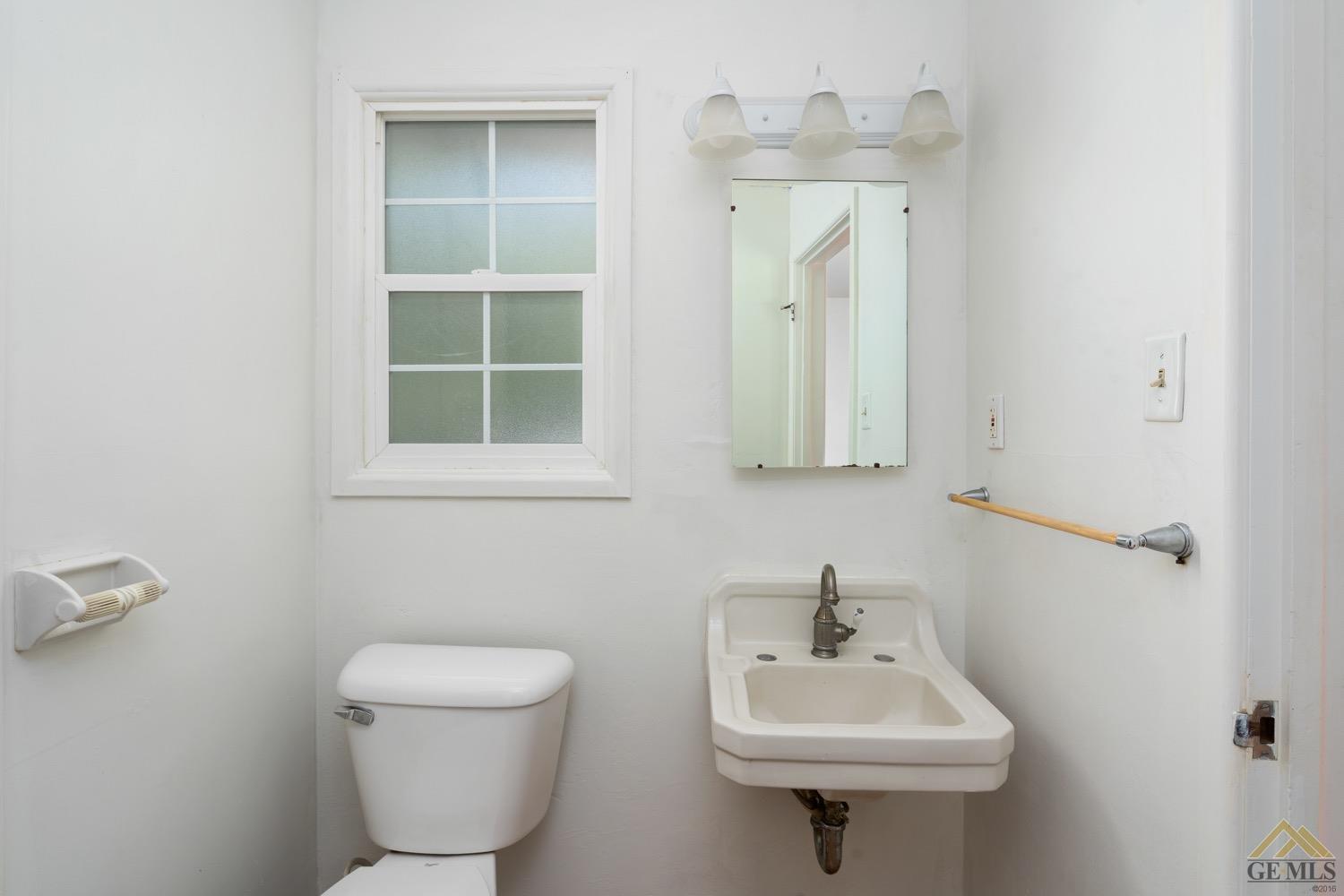 Undisclosed Address Bakersfield, CA 93301 - Photo 11 of 21 a bathroom with a toilet sink and mirror