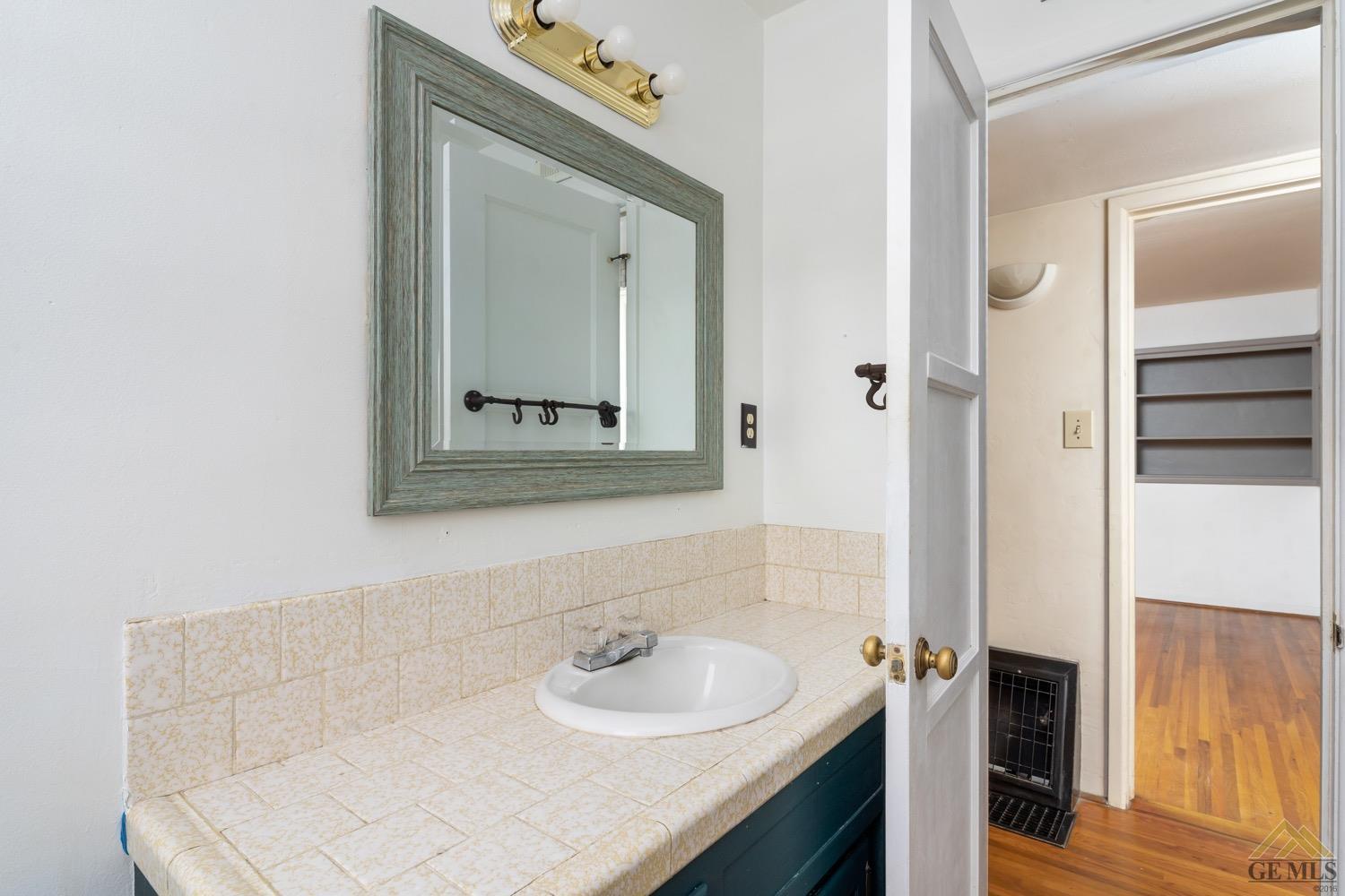 Undisclosed Address Bakersfield, CA 93301 - Photo 17 of 21 a bathroom with a sink and a mirror