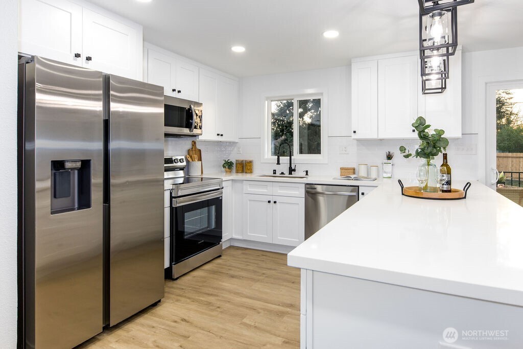 1101 Vashon Court Northeast Renton, WA 98059 - Photo 6 of 30 a kitchen with stainless steel appliances a refrigerator sink and stove