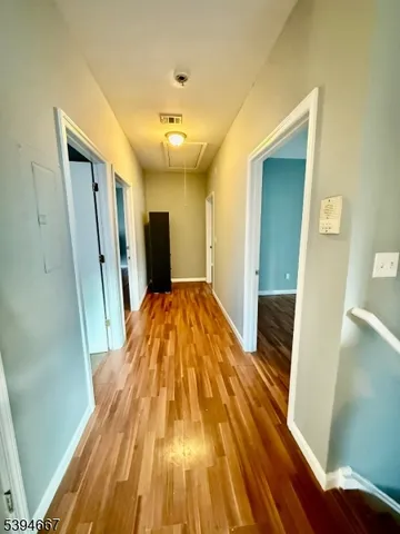 a view of a hallway with wooden floor