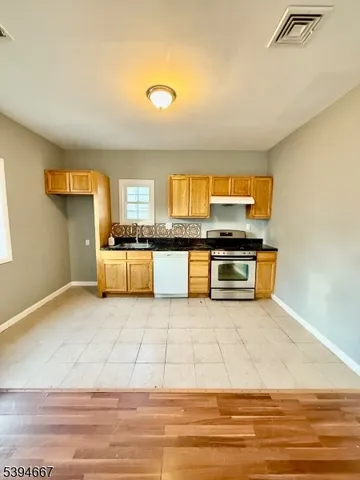 a view of kitchen with stainless steel appliances granite countertop cabinets and window