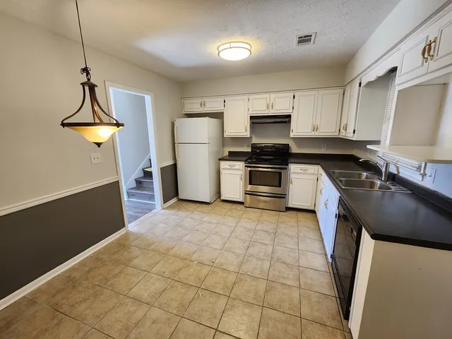 a kitchen with stainless steel appliances cabinets a sink and a stove