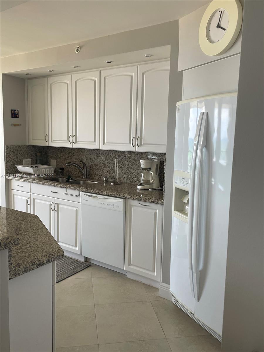 Beach Pompano Beach, FL 33062 - Photo 6 of 17 a kitchen with granite countertop white cabinets and refrigerator