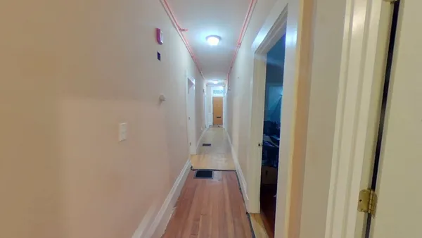 a view of a hallway with wooden floor