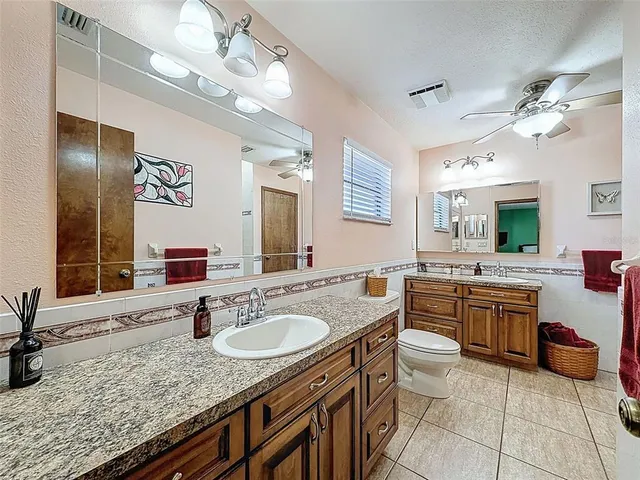a bathroom with a granite countertop sink a mirror and a bathtub