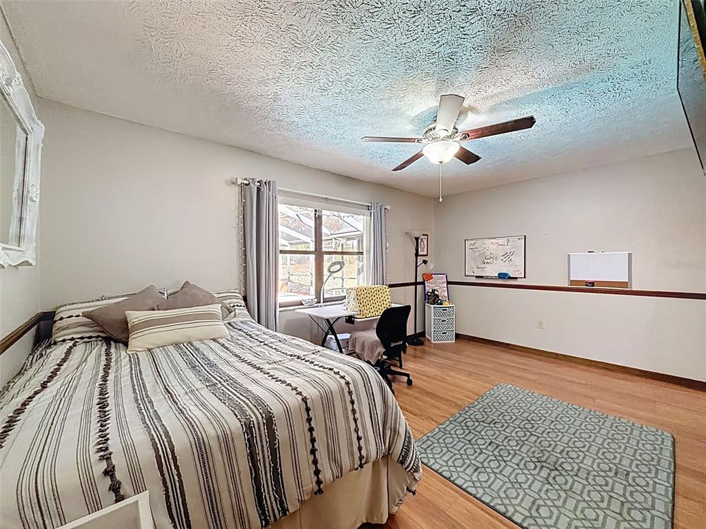4289 Castle Avenue Spring Hill, FL 34609 - Photo 22 of 50 a bedroom with a bed and a chandelier