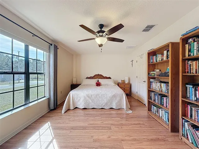 a bedroom with a large bed and a book shelf