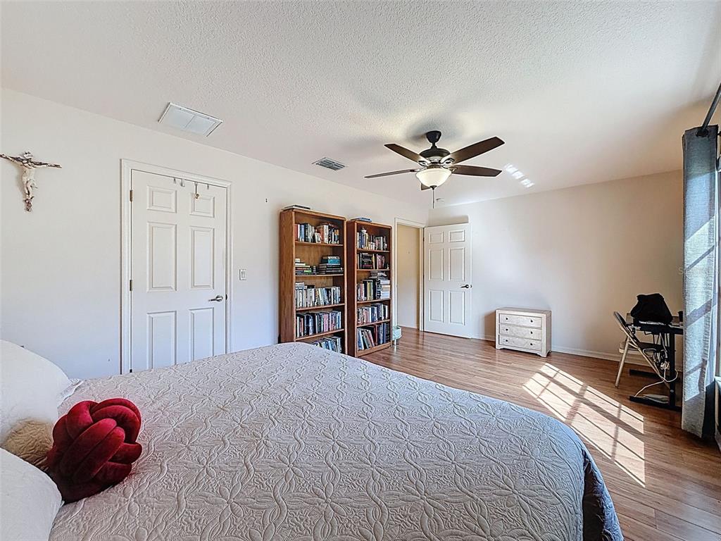 4289 Castle Avenue Spring Hill, FL 34609 - Photo 24 of 50 a bedroom with a large bed and a chandelier