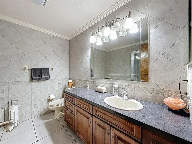 a bathroom with a granite countertop sink a toilet and a mirror