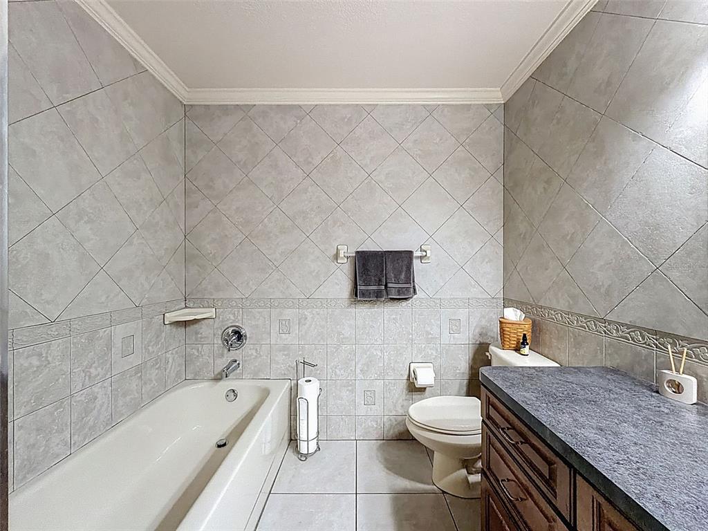4289 Castle Avenue Spring Hill, FL 34609 - Photo 29 of 50 a bathroom with a granite countertop bathtub sink vanity mirror and toilet