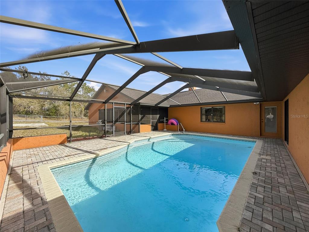 4289 Castle Avenue Spring Hill, FL 34609 - Photo 35 of 50 a view of a backyard with table and chairs under an umbrella