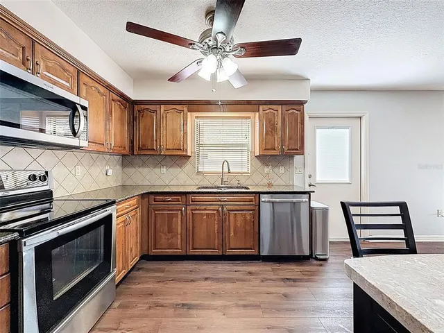 a kitchen with stainless steel appliances granite countertop a stove and a sink