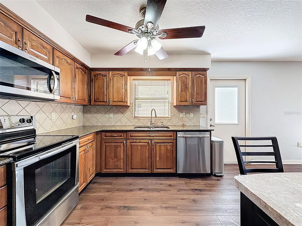 4289 Castle Avenue Spring Hill, FL 34609 - Photo 42 of 50 a kitchen with stainless steel appliances granite countertop a stove and a sink