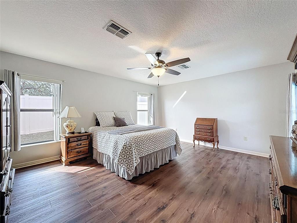 4289 Castle Avenue Spring Hill, FL 34609 - Photo 48 of 50 a spacious bedroom with a bed and a chandelier