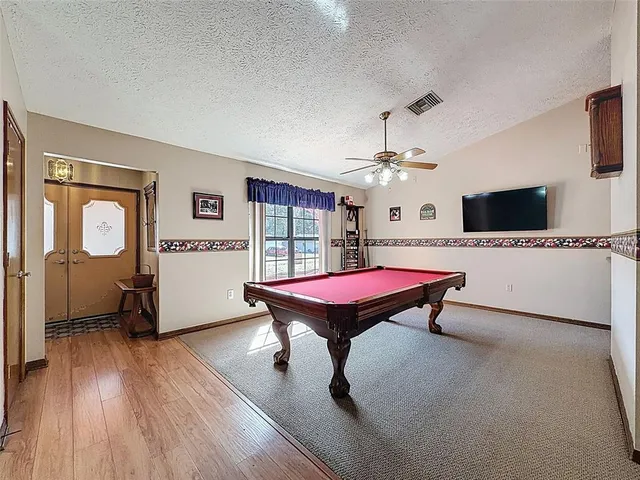 a room with pool table and windows