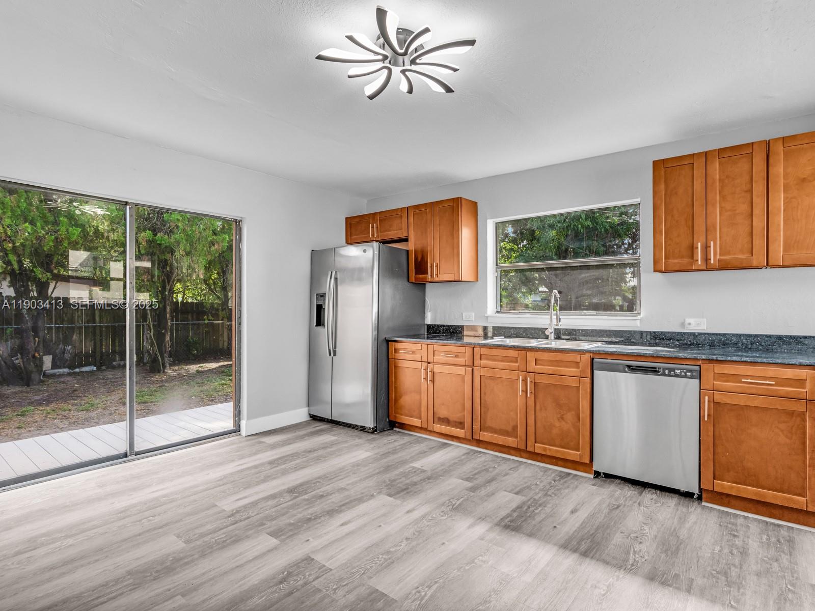 6238 Southwest 24th Street Miramar, FL 33023 - Photo 11 of 33 a kitchen with stainless steel appliances granite countertop a refrigerator a sink a stove a washer dryer and white cabinets