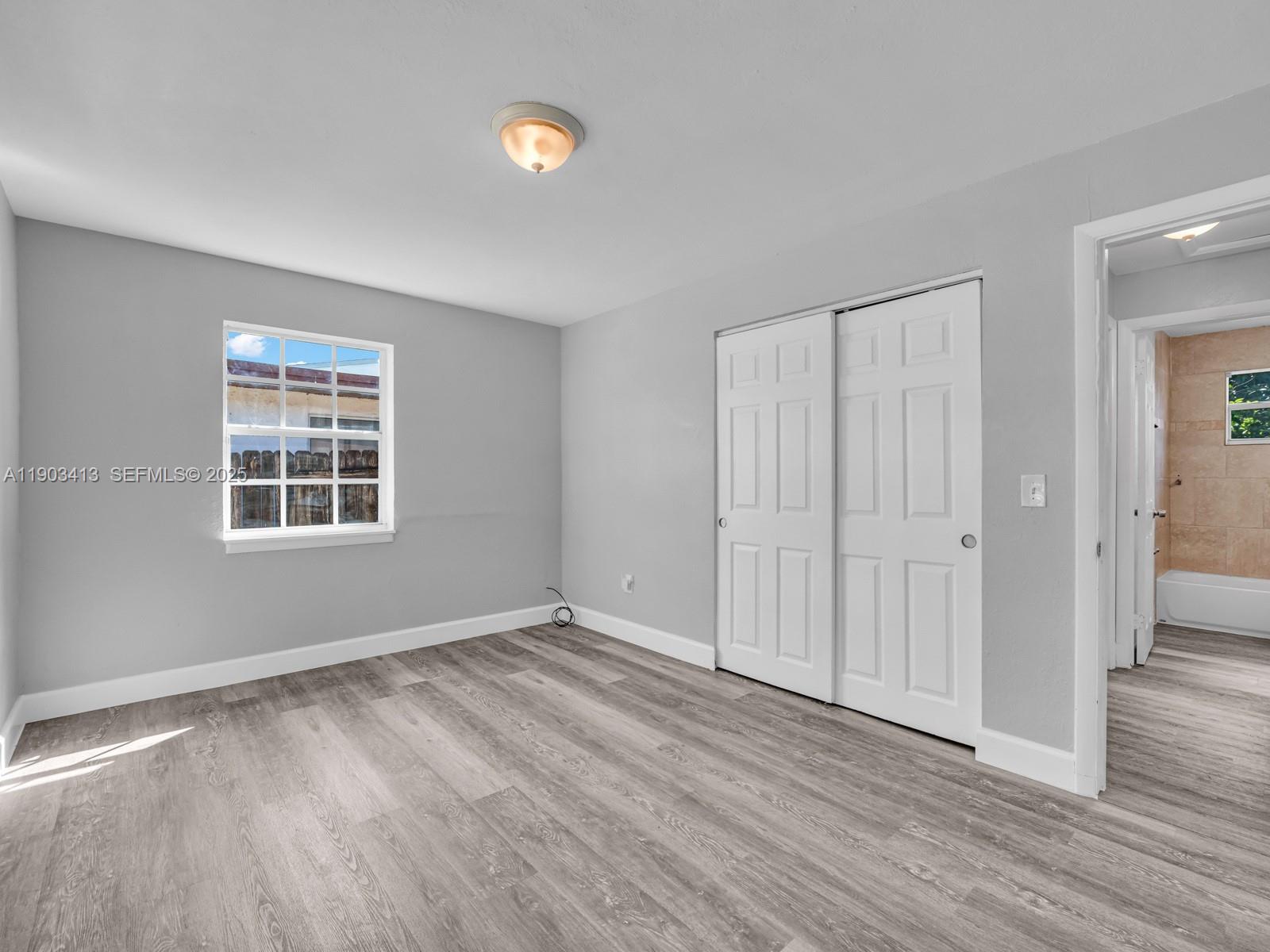 6238 Southwest 24th Street Miramar, FL 33023 - Photo 17 of 33 a view of an empty room with wooden floor and a window