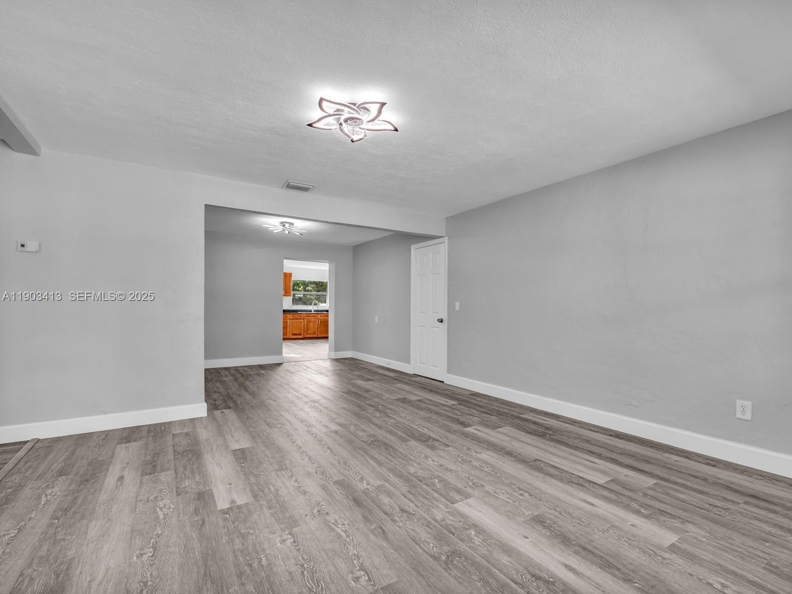 6238 Southwest 24th Street Miramar, FL 33023 - Photo 5 of 33 a view of an empty room with wooden floor and a window