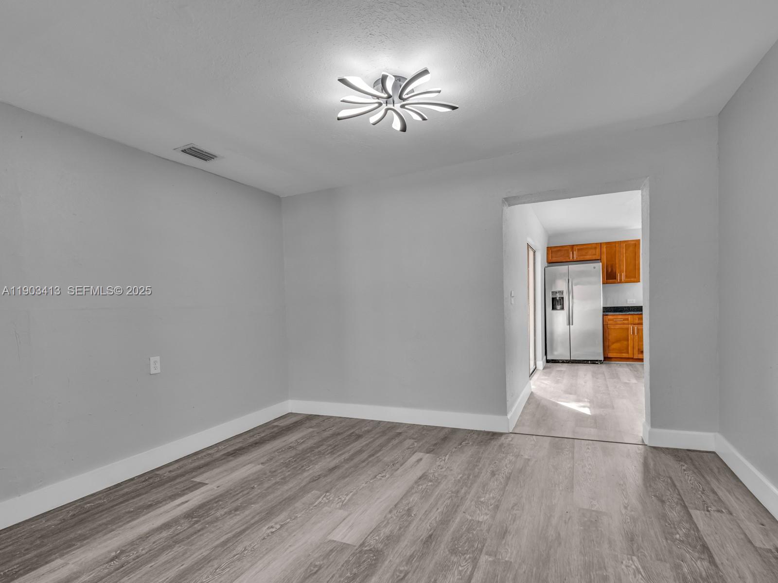 6238 Southwest 24th Street Miramar, FL 33023 - Photo 7 of 33 an empty room with wooden floor and a ceiling fan