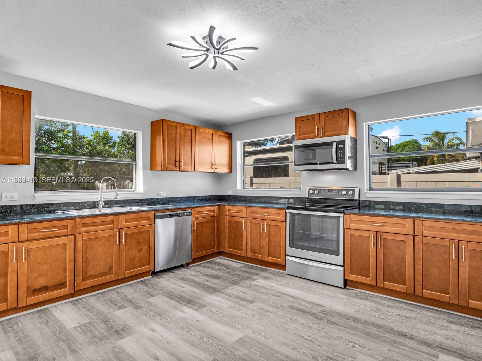 6238 Southwest 24th Street Miramar, FL 33023 - Photo 10 of 33 a large kitchen with stainless steel appliances granite countertop a stove and a sink