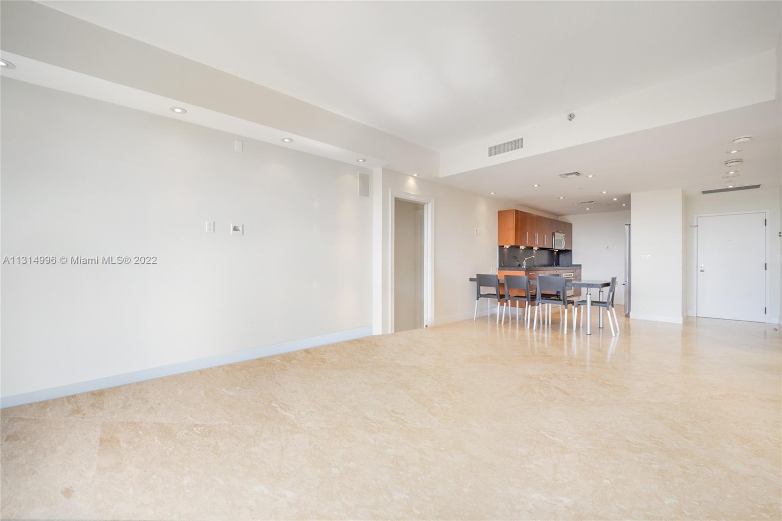 151 Crandon Boulevard, Unit 439 Key Biscayne, FL 33149 - Photo 4 of 24 a view of a kitchen with dining table and chairs