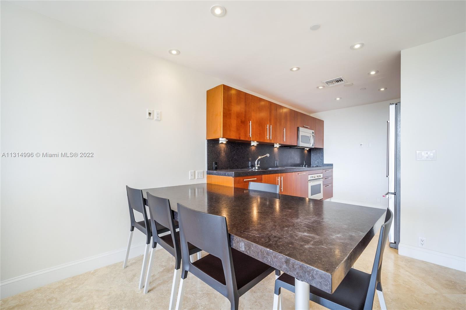 151 Crandon Boulevard, Unit 439 Key Biscayne, FL 33149 - Photo 6 of 24 a dining room with furniture and wooden floor