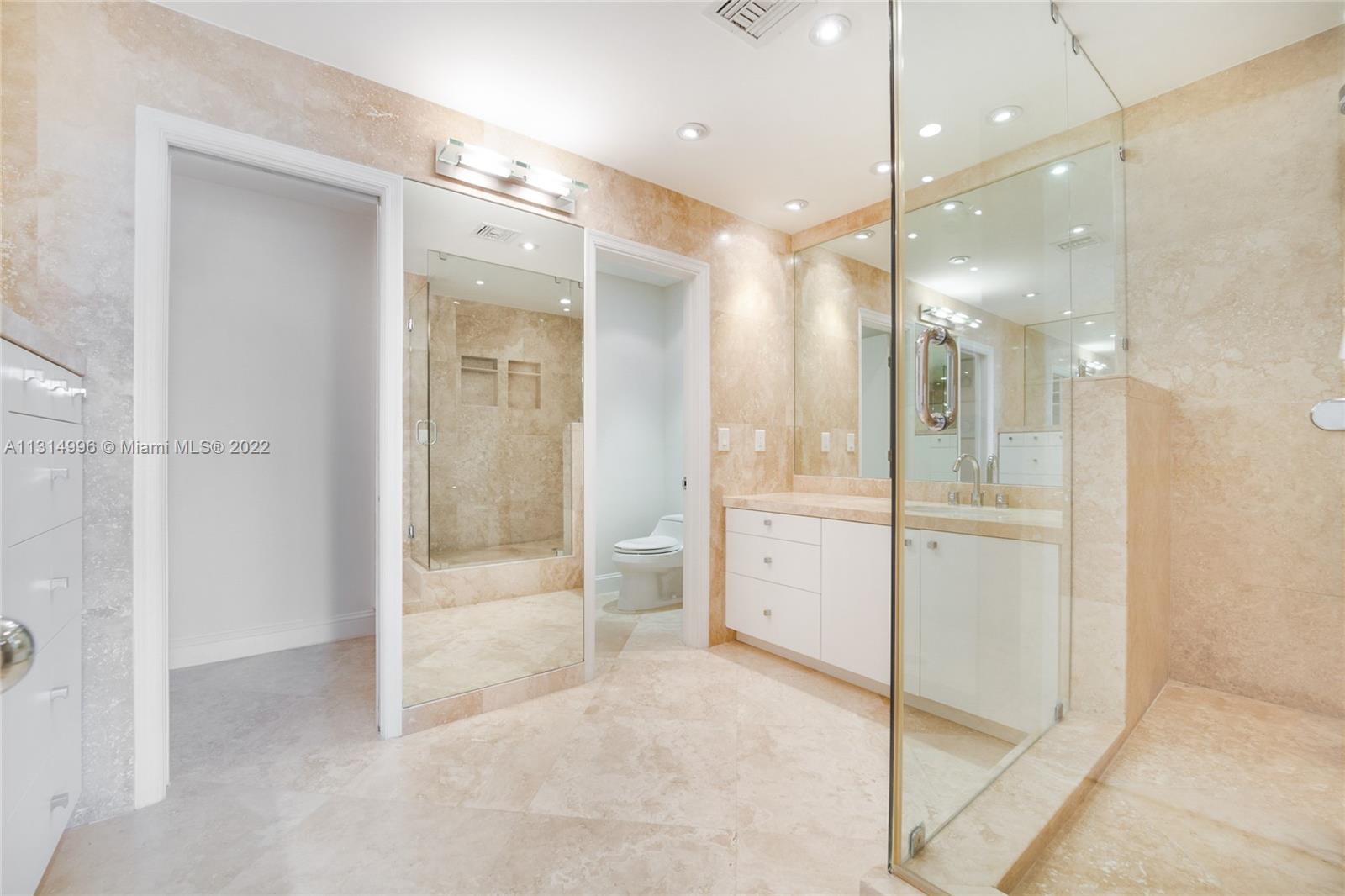 151 Crandon Boulevard, Unit 439 Key Biscayne, FL 33149 - Photo 9 of 24 a bathroom with a glass shower door and a sink