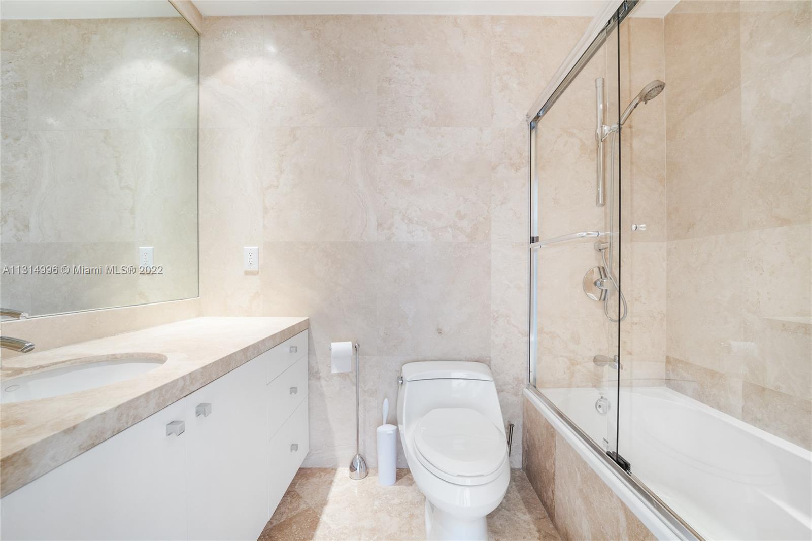 151 Crandon Boulevard, Unit 439 Key Biscayne, FL 33149 - Photo 10 of 24 a bathroom with a granite countertop sink a toilet and shower