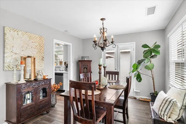 a view of a dining room with furniture a chandelier and wooden floor