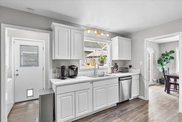 a kitchen with a sink cabinets and wooden floor