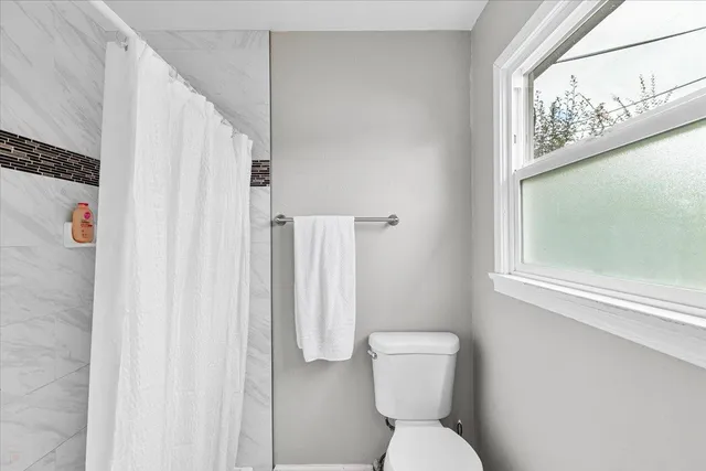 a white toilet sitting next to a bathroom