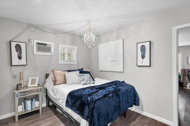 a bedroom with a large bed and a chandelier