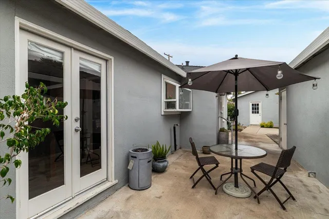 a patio with a table and chairs under an umbrella