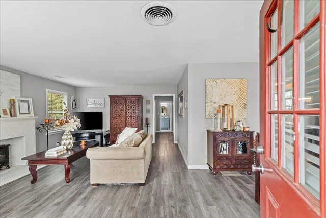 a living room with furniture a fireplace and a large window