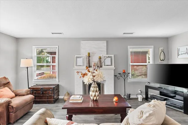 a living room with furniture a flat screen tv and a window