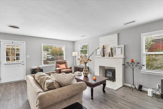 a living room with furniture a large window and a fireplace