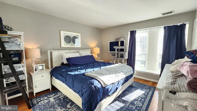 a bedroom with a bed and wooden floor