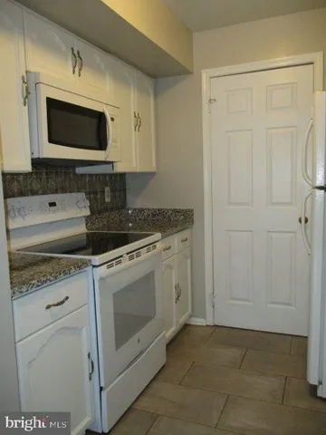 a kitchen with stainless steel appliances granite countertop a stove a microwave and a refrigerator