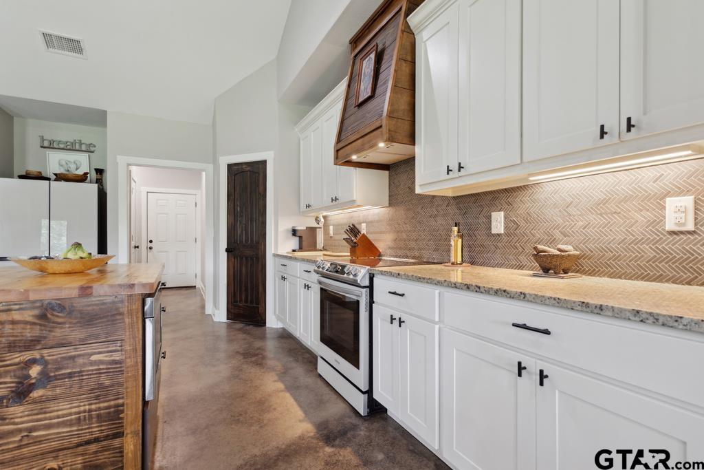 15767 County Road 285 Tyler, TX 75707 - Photo 15 of 44 a kitchen with stainless steel appliances granite countertop a stove a sink and a refrigerator