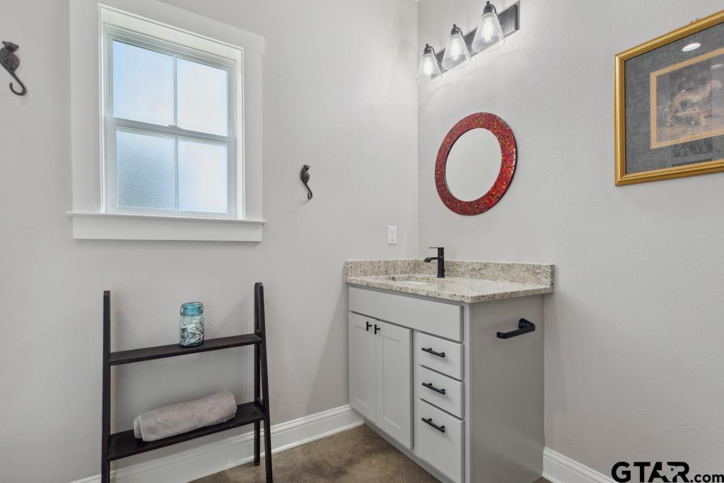 15767 County Road 285 Tyler, TX 75707 - Photo 28 of 44 a bathroom with a granite countertop sink and a mirror