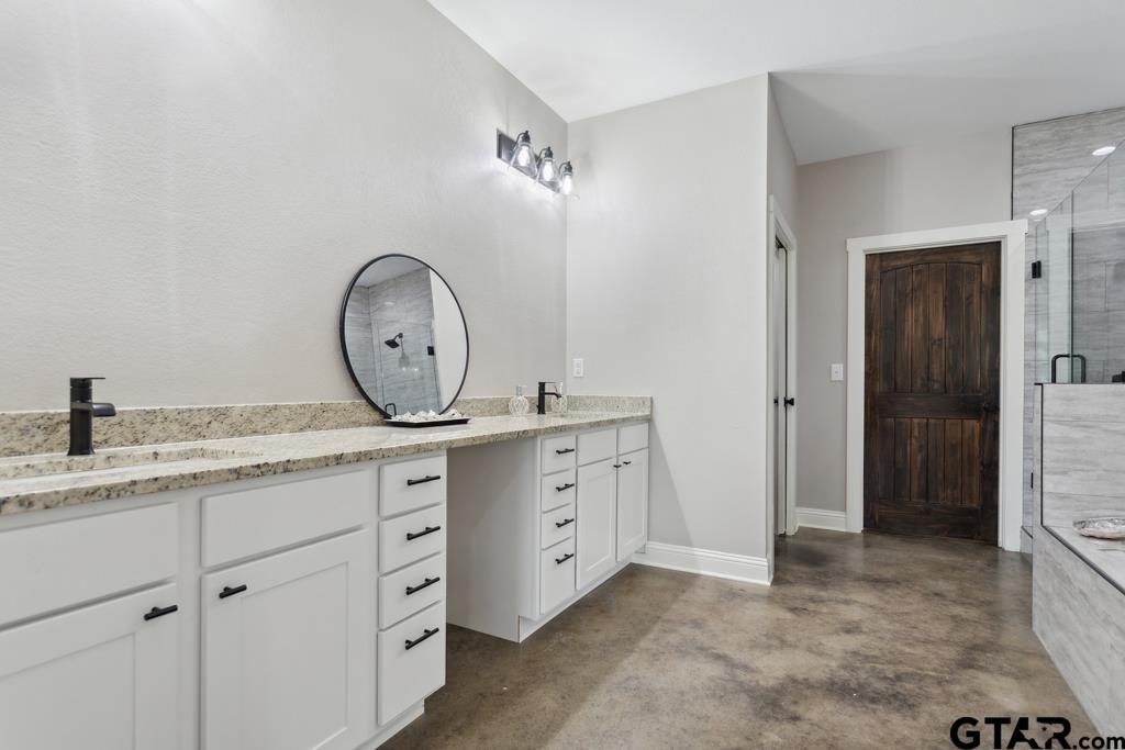 15767 County Road 285 Tyler, TX 75707 - Photo 8 of 44 a spacious bathroom with a granite countertop sink a mirror and a toilet