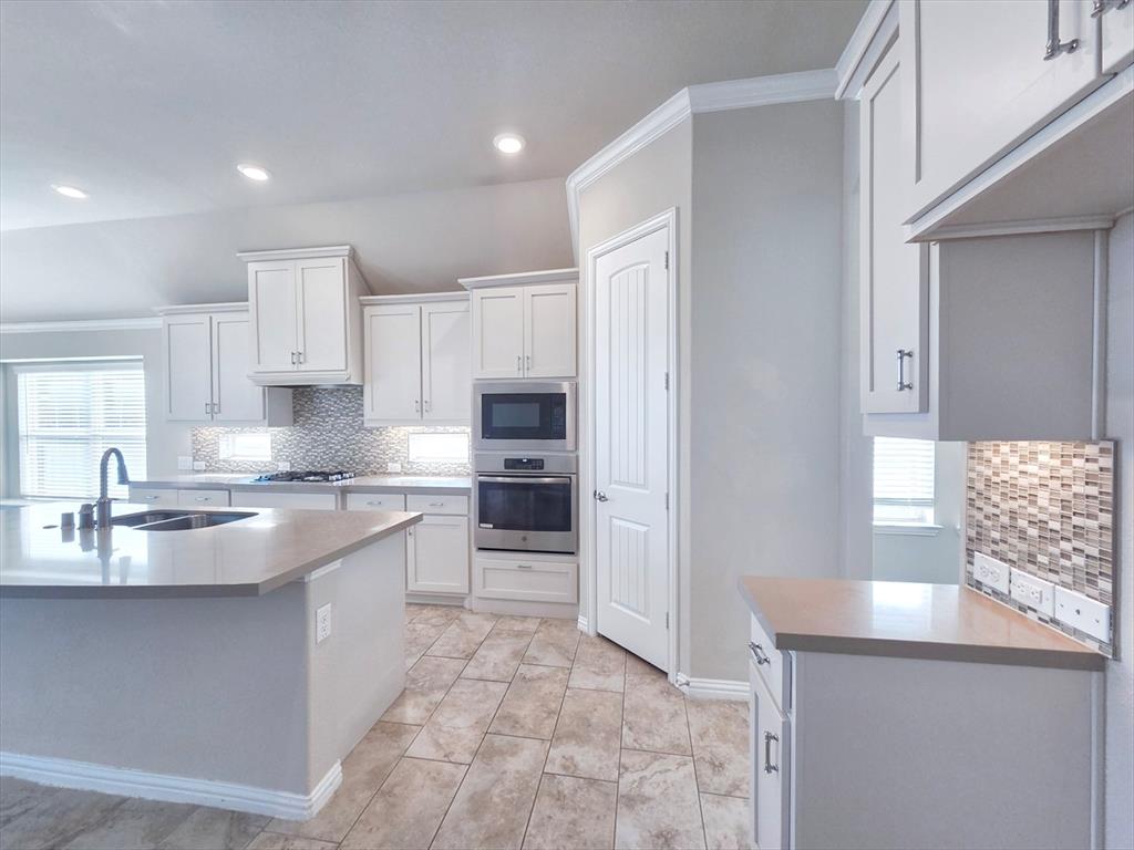 355 Prairie Ridge Lane Lewisville, TX 75056 - Photo 11 of 24 a kitchen with stainless steel appliances granite countertop a sink stove and refrigerator