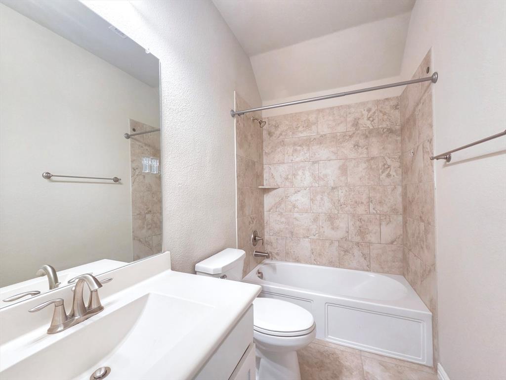 355 Prairie Ridge Lane Lewisville, TX 75056 - Photo 20 of 24 a bathroom with a sink a toilet a mirror and a bathtub